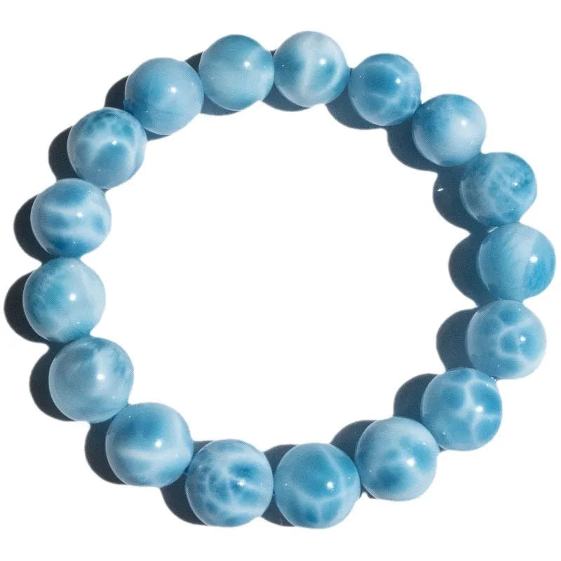 Blue Bodhi bead bracelet with a natural crystal sea-pattern stone charm on a wrist.