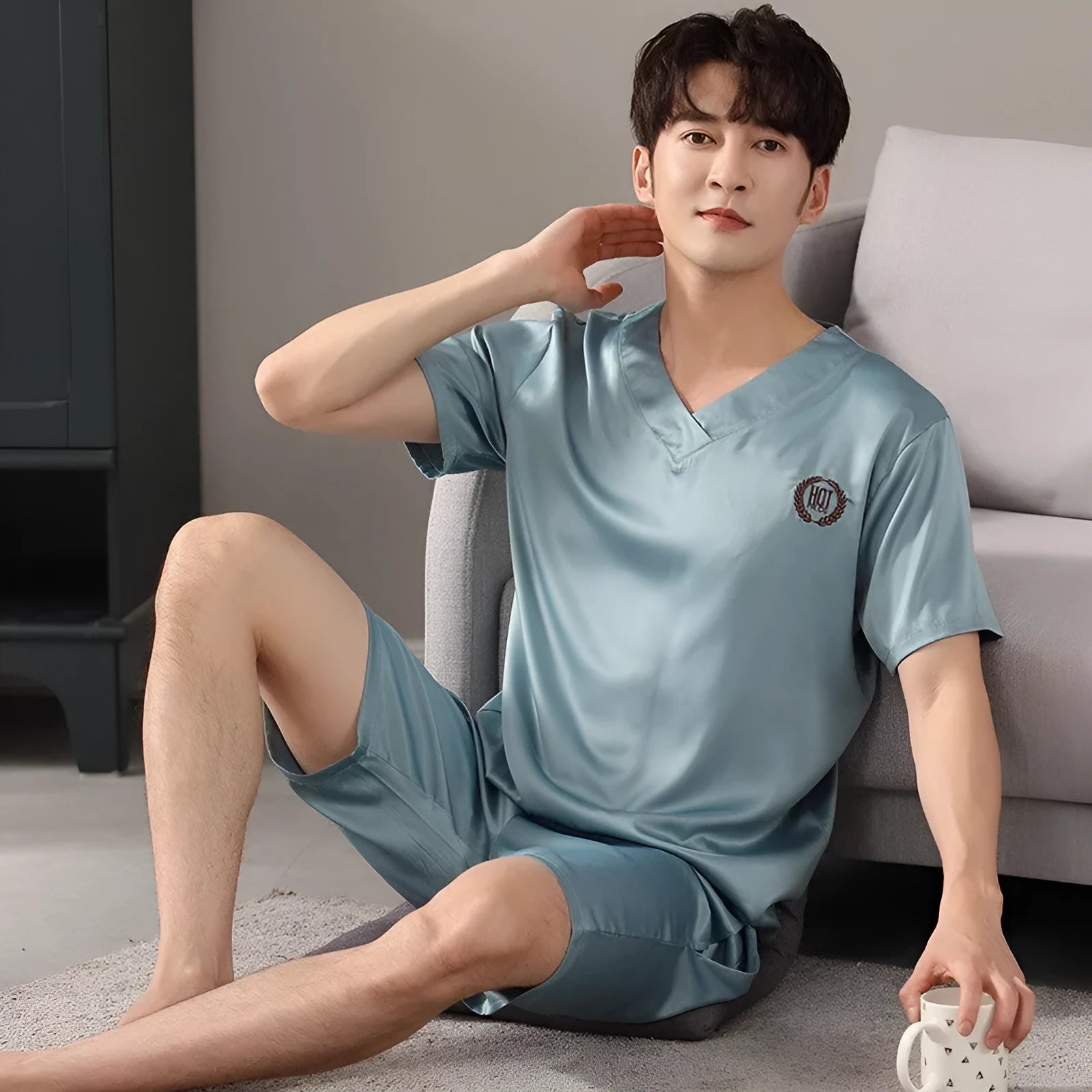 Men's ice silk short-sleeved pajama shirt and loose shorts set on a hanger.