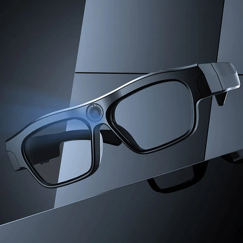 Black head-mounted smart Bluetooth glasses with a built-in camera for video recording on a table with accessories.