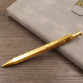 Solid brass cylindrical tactical pen with a press mechanism and six-ring detail.