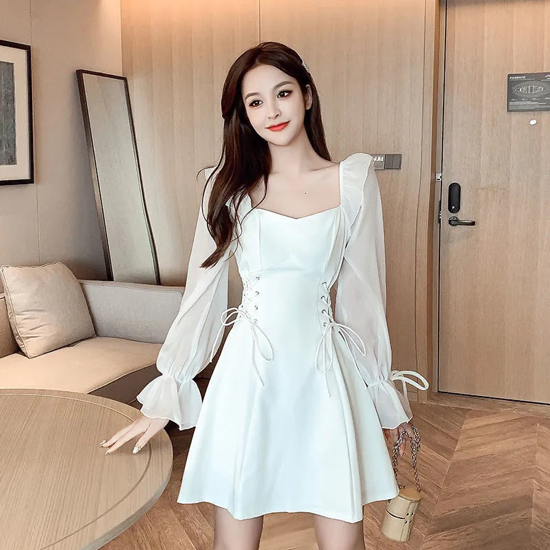 White women's long sleeve dress with chiffon patchwork detailing and a long, slimming skirt.