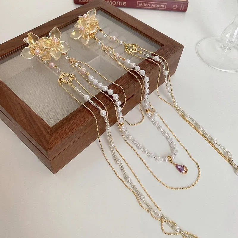 Gold grip hairpin with white pearl, clear diamond, flower decoration, and a long beaded tassel.