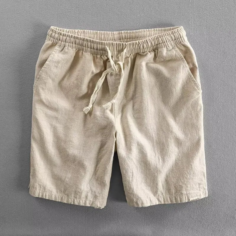 Man wearing loose-fit beige cotton linen casual shorts on a beach
