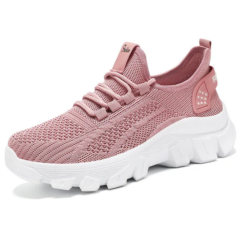 Women's white Flyknit sneakers with thick PVC sole and lace-up design on a neutral background.