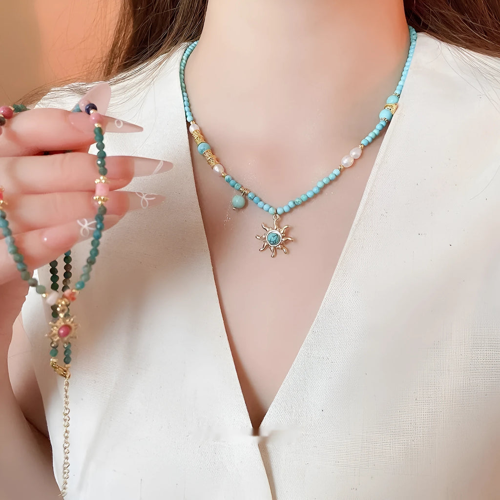 Freshwater pearl necklace with stone sun pendant on adjustable clavicle chain in blue and golden pink colours