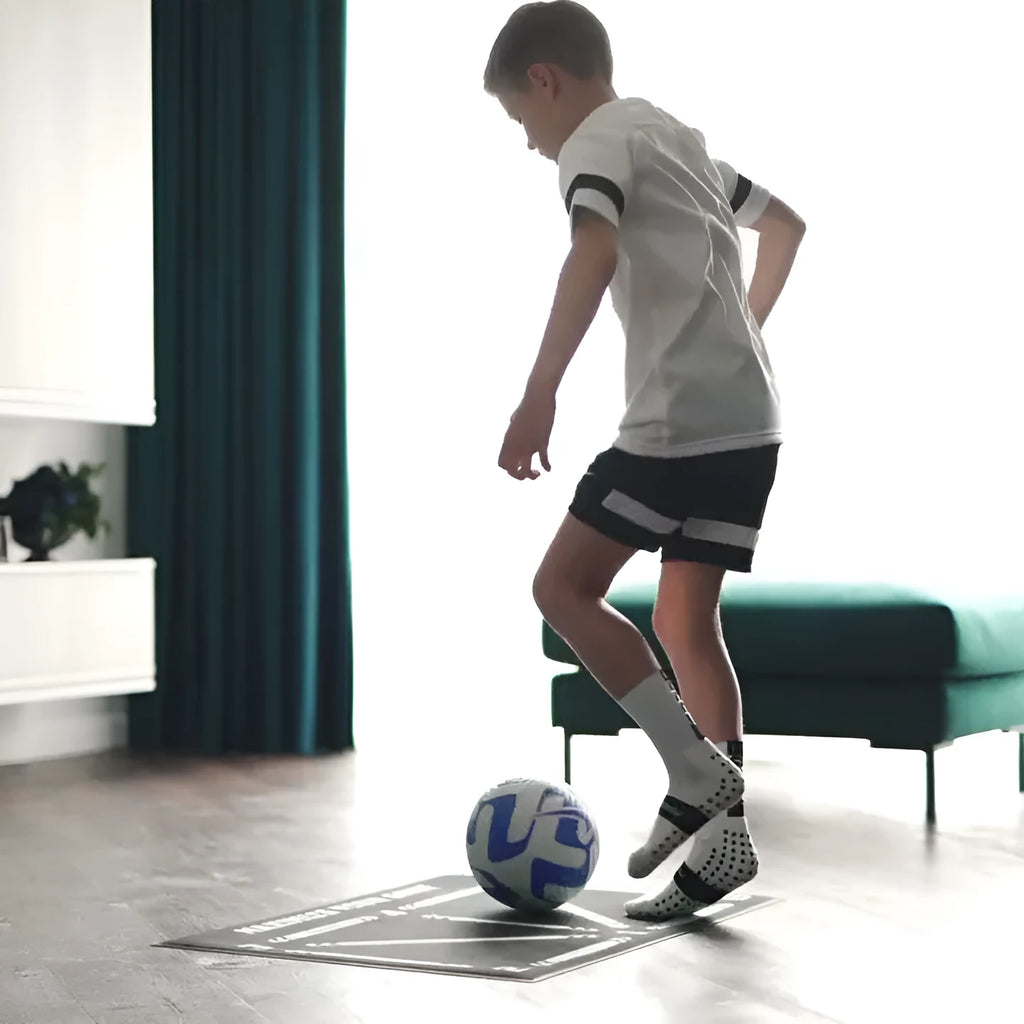 Black rectangular football training mat on floor for ball control practice drills