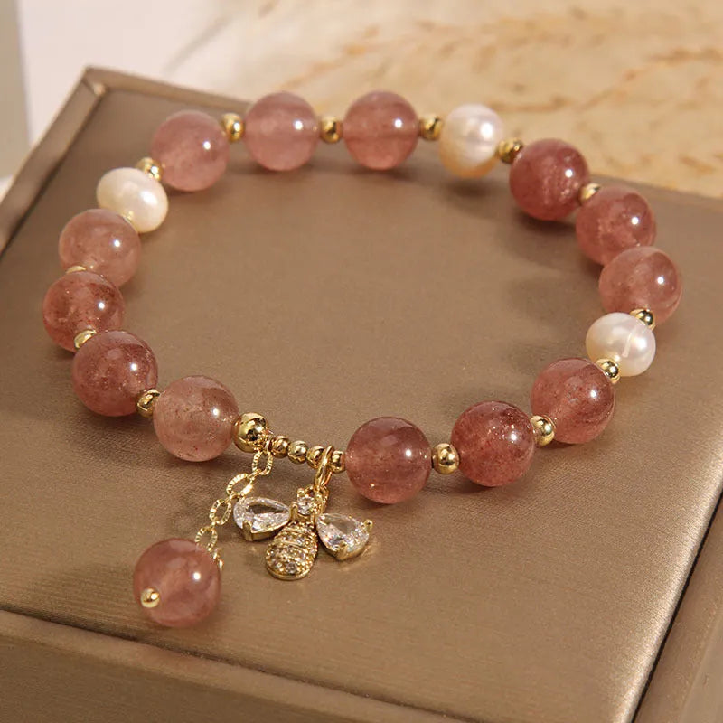 Women's bracelet with strawberry quartz beads, freshwater pearls, and a bee charm.