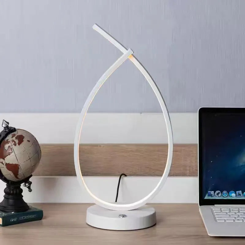 Modern black water drop shaped USB table lamp with touch control on wooden bedside table