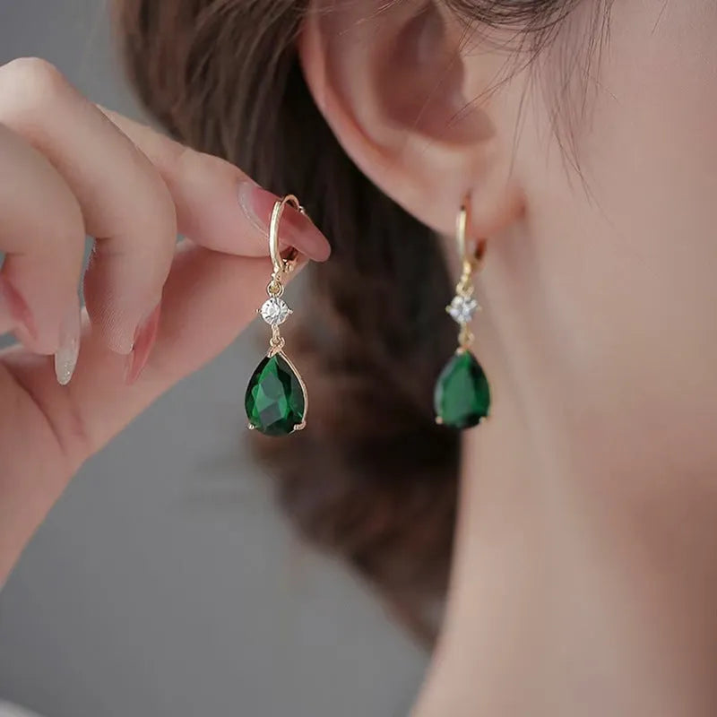 Geometric green teardrop alloy earrings on a plain background