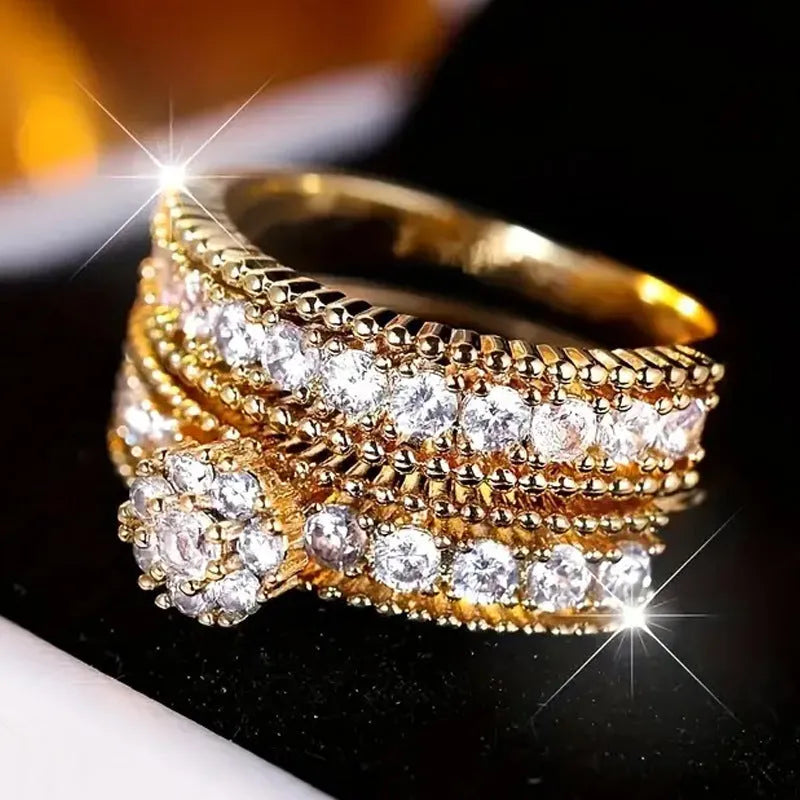 Two geometric gold electroplated zinc alloy rings on a flat surface