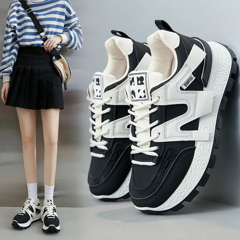 Low-top white and black casual sneakers with round toe and lace-up front