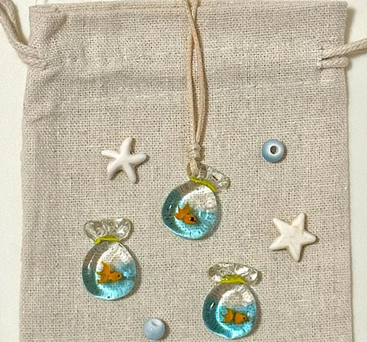 Women's necklace with coloured glaze joker pendant on a beige cotton and linen clavicle chain.