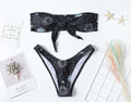 Black one-piece swimsuit with bikini print split tube top and backless design.