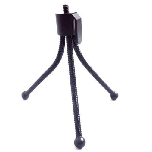 Small black iron mini tripod with ball head extended, next to an iPhone on a desk