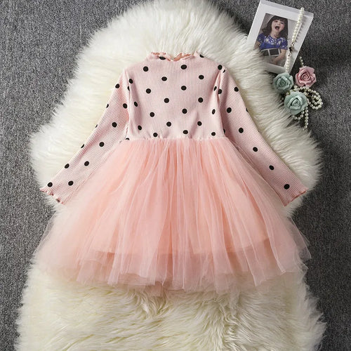 Baby girl in a long sleeve black tutu lace dress for a christening or birthday party.