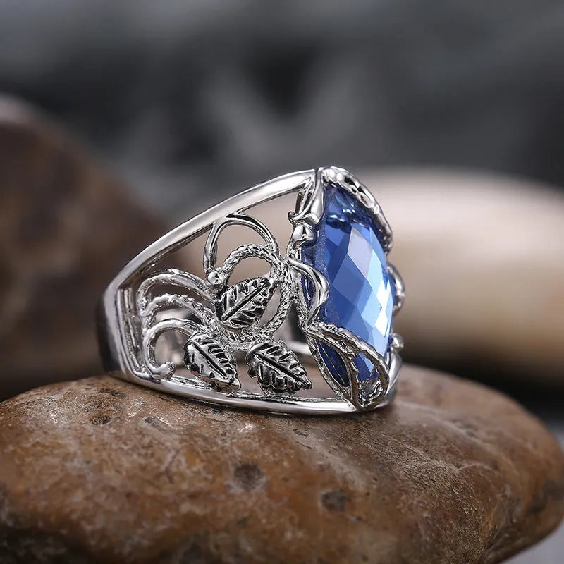 Blue crystal inlaid in a geometric horse eye shape on an alloy women's ring.