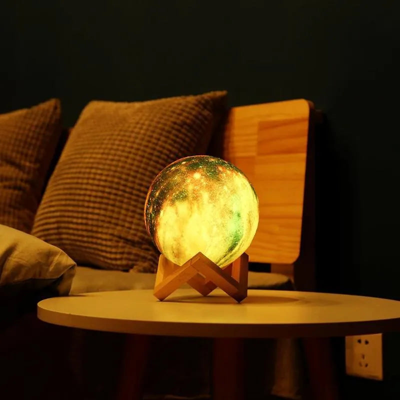 3D printed spherical lunar night light glowing with soft colour-changing LED light on a dark surface.