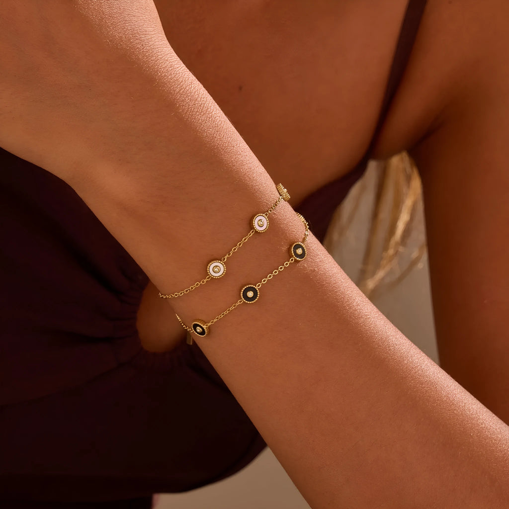 Close-up of a women's geometric fritillary pattern bracelet and necklace set in gold-plated stainless steel.