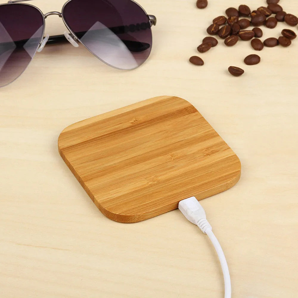 Square brown bamboo 5W wireless charging pad on a wooden table