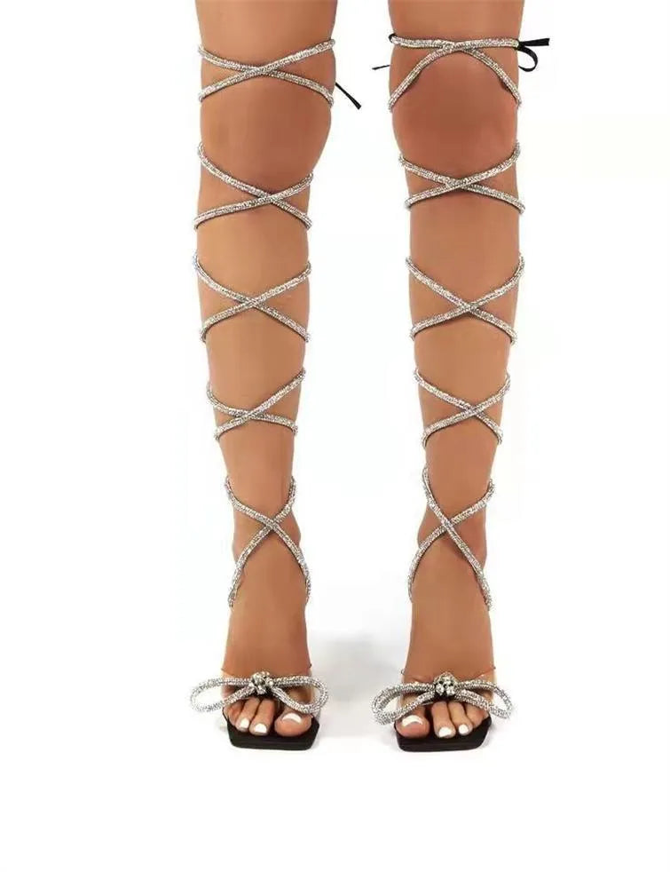Plus size women's black strappy sandals with rhinestone decorations and a square toe.