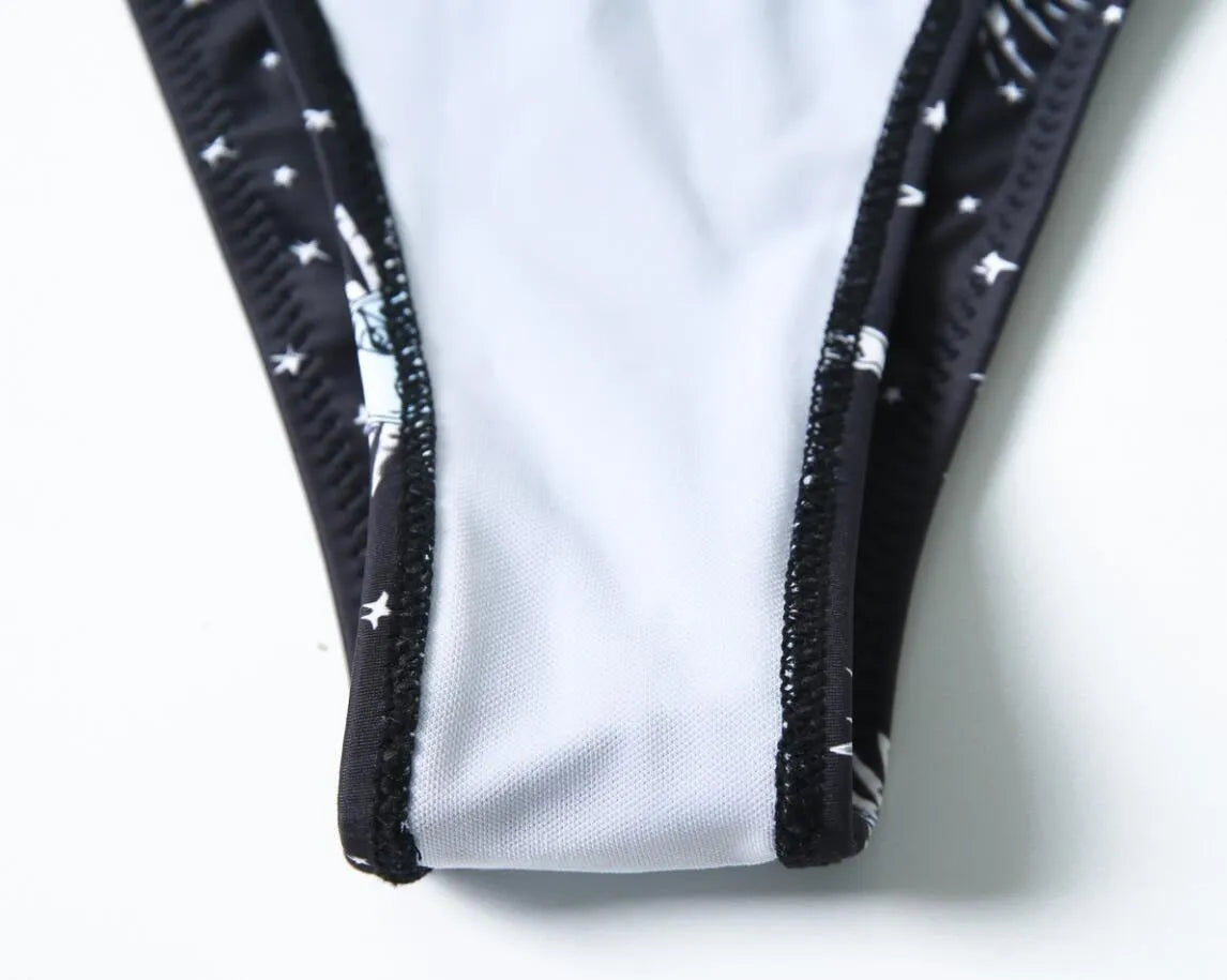 Black one-piece swimsuit with bikini print split tube top and backless design.