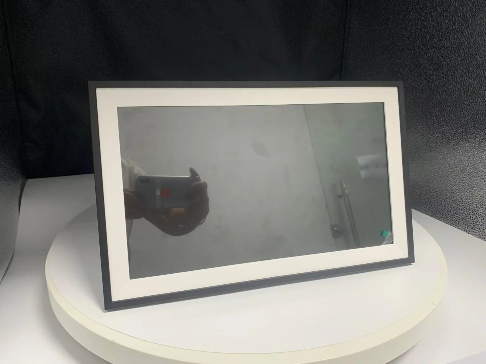 White 15.6-inch smart digital photo frame showing family photographs with adjustable stand