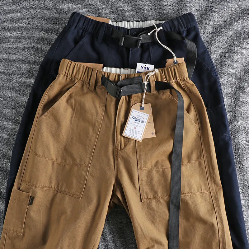 Man's khaki cotton canvas work trousers with 3D cut, showing mid-rise waist and zipper fly.