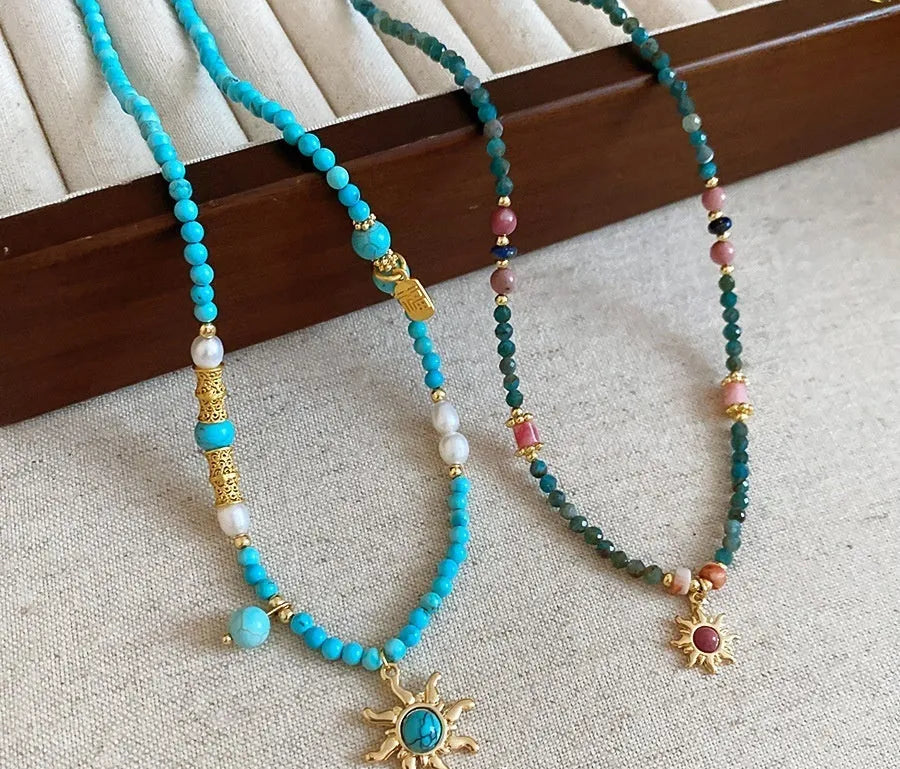 Freshwater pearl necklace with stone sun pendant on adjustable clavicle chain in blue and golden pink colours