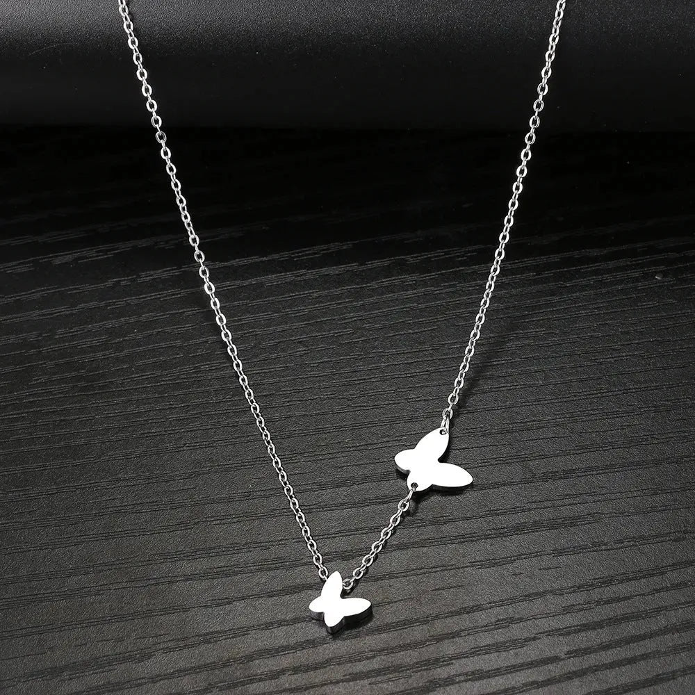 Butterfly pendant necklace in stainless steel with 18K gold electroplated finish on a white background
