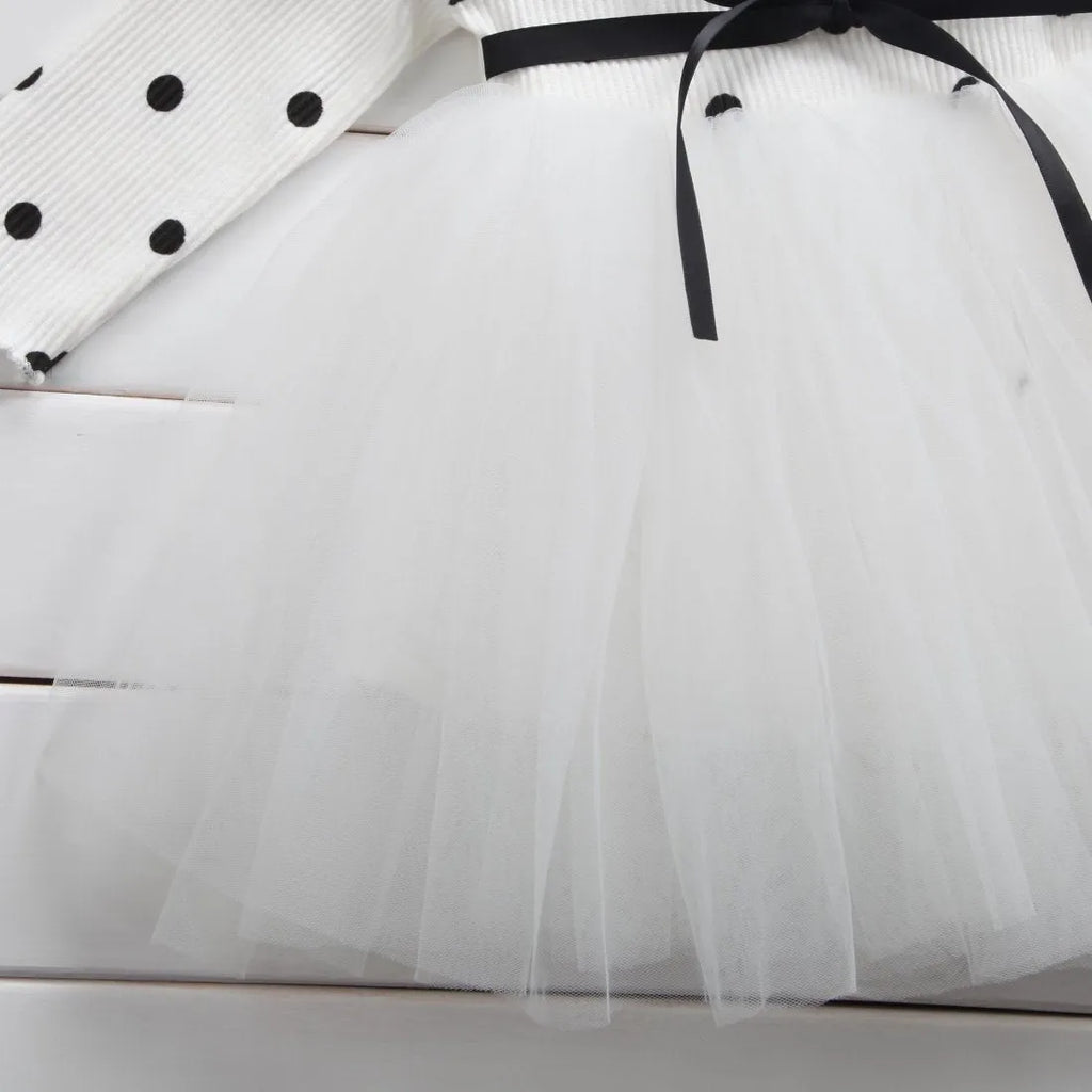 Baby girl in a long sleeve black tutu lace dress for a christening or birthday party.