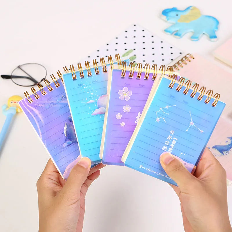 Set of four A7 spiral-bound notebooks with PP covers in different designs, showing compact 10.8 x 8.2 cm size