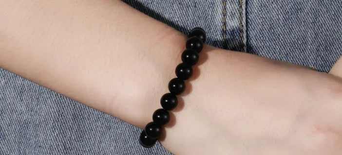 Geometric black agate beaded bracelet with 8mm stones on a black elastic cord.