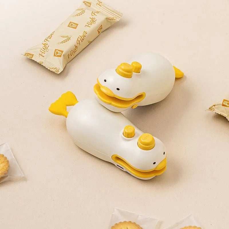 Yellow duck jacquard patterned rechargeable handheld bag sealing machine with USB charging cable.