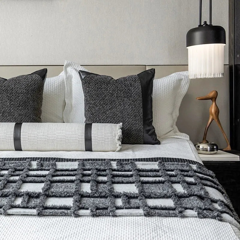 Grey and white plaid bed runner blanket with leather round pillow on 1.5m bed