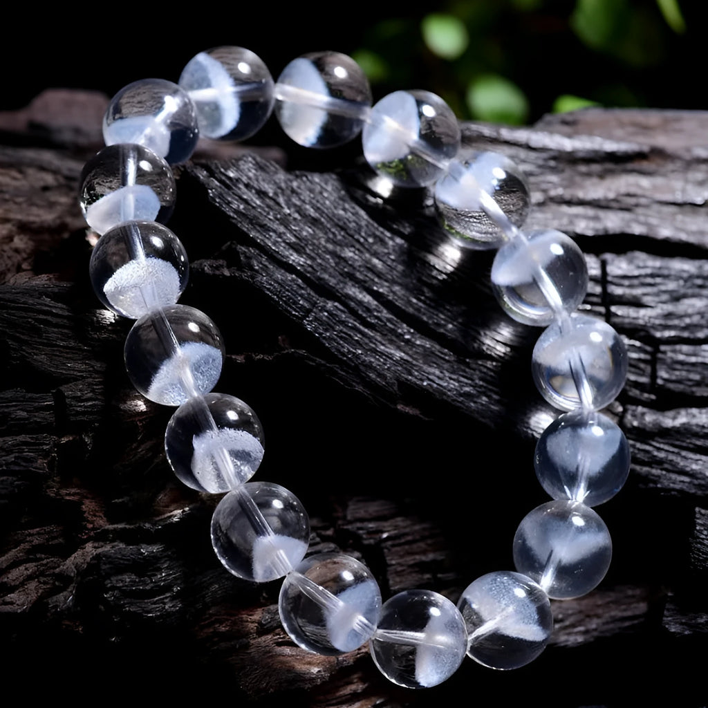 Women's white crystal pyramid bead bracelet with a silver ruyi charm on a white background.