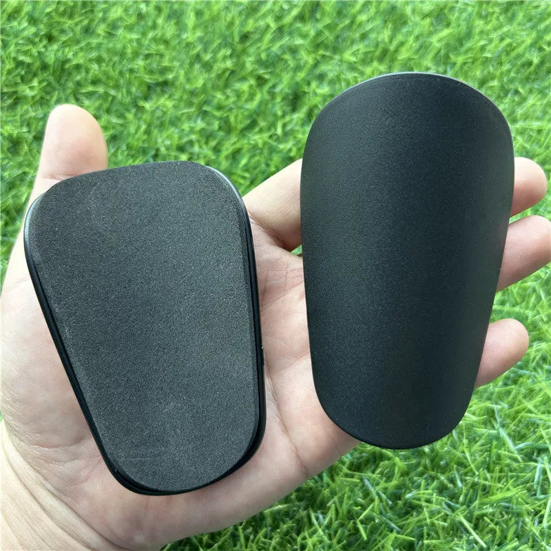 Extra small plastic football shin guards in black or white colour options