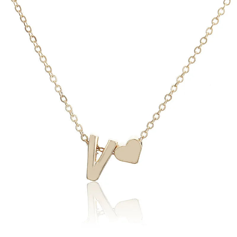 Gold alloy peach heart pendant necklace with a letter detail on a delicate chain.