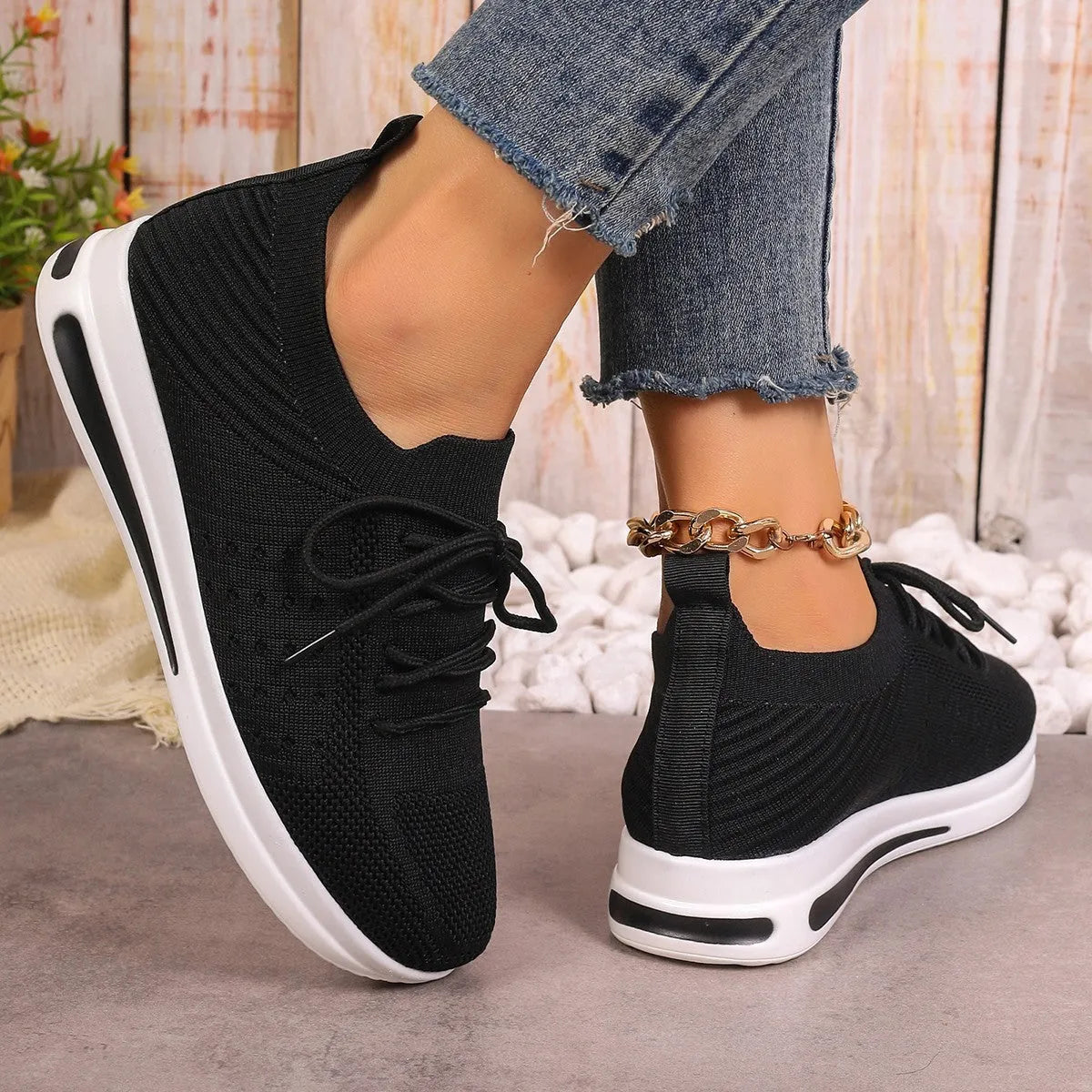 Women's black fly-knit casual sneakers with low-top design and round toe.