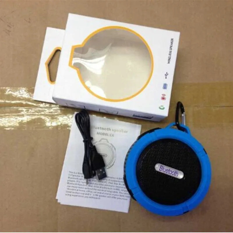 Portable waterproof Bluetooth speaker in blue with a mountaineering buckle clip for bags.
