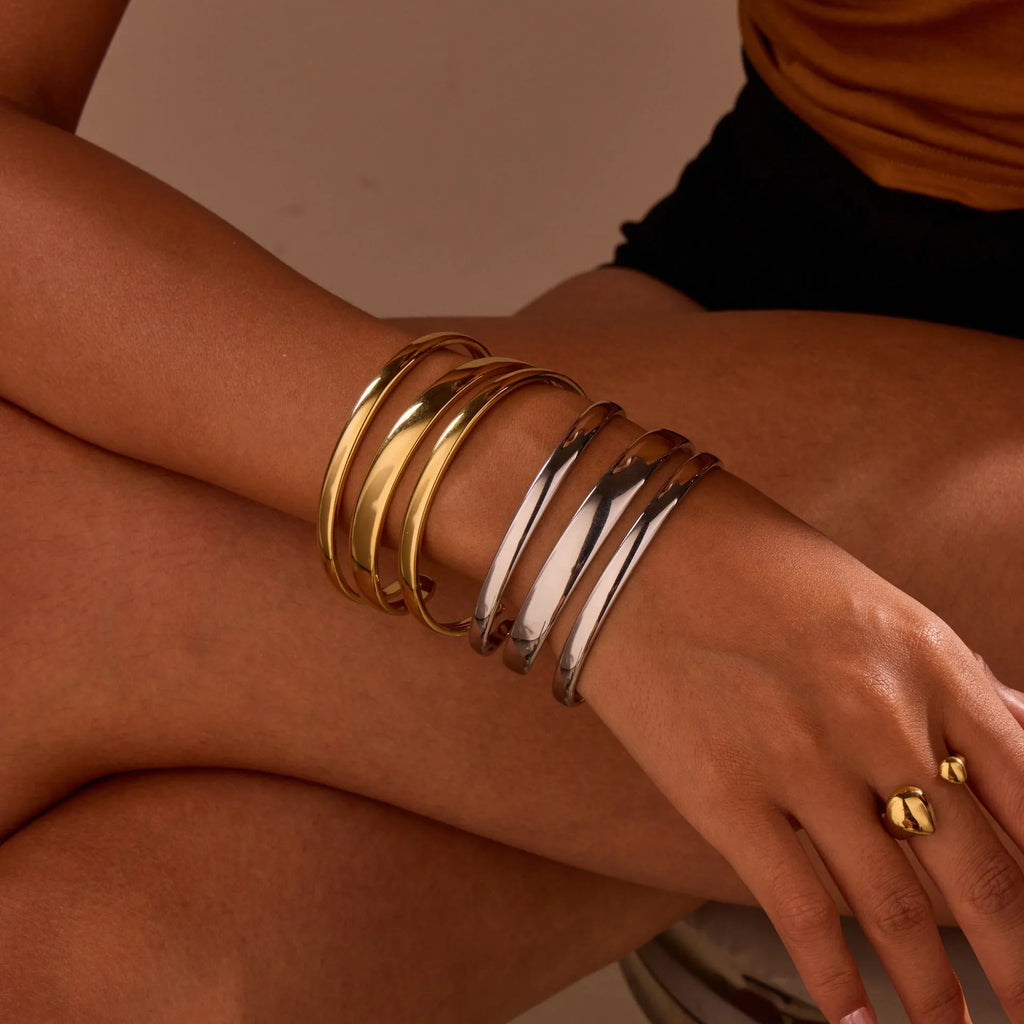 Stainless steel women's bracelet with geometric line design, shown in gold and steel finish options