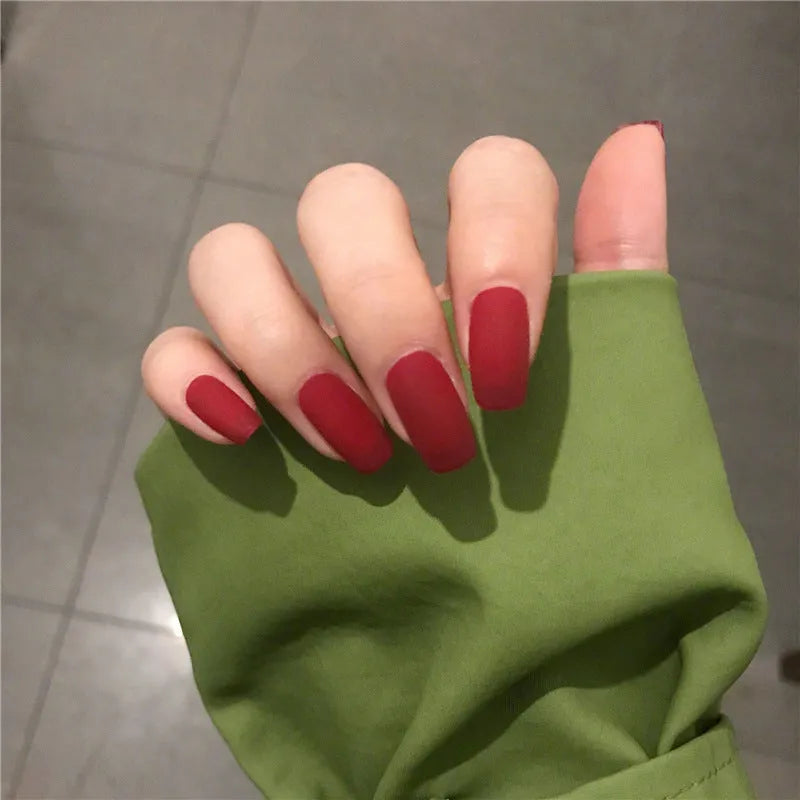 24 false nails in matte red medium length with glue adhesive in packaging