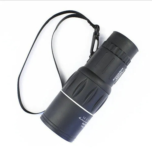 Black 16x52 monocular telescope showing eyepiece and objective lens, placed on a surface.