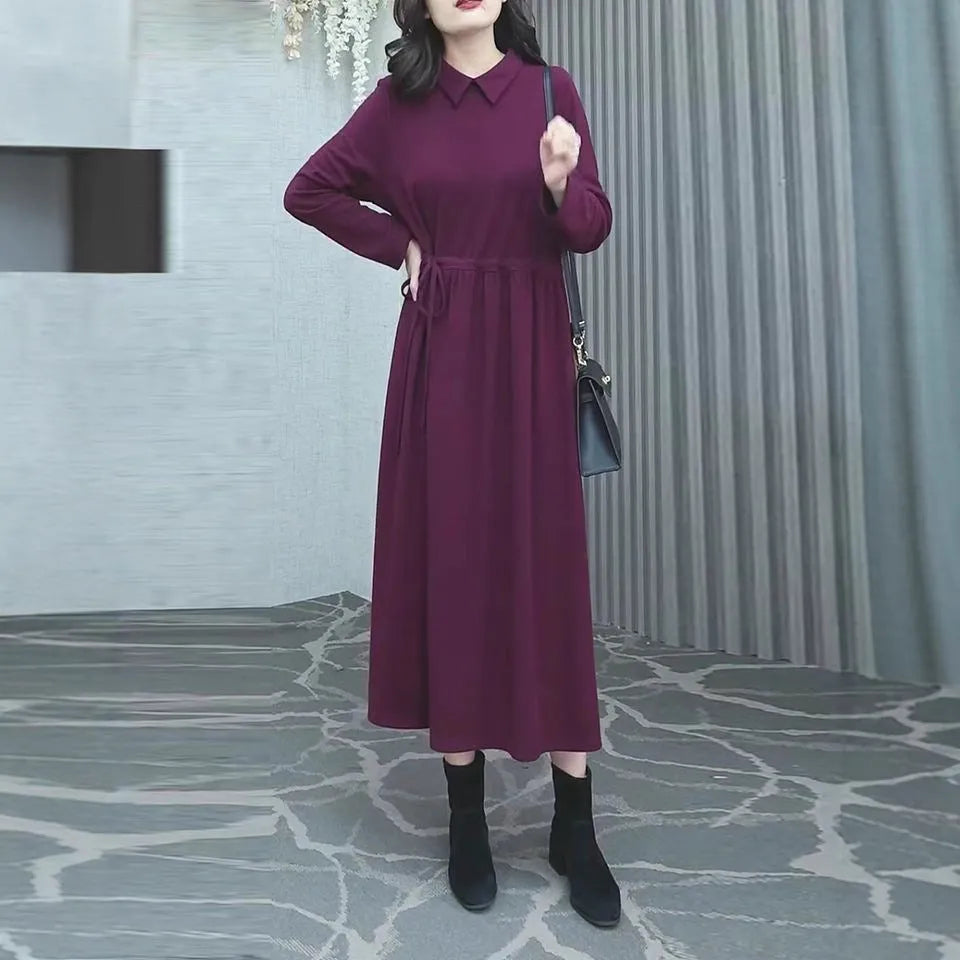 Purplish red women's plus size long sleeve dress with a long skirt, shown on a hanger.