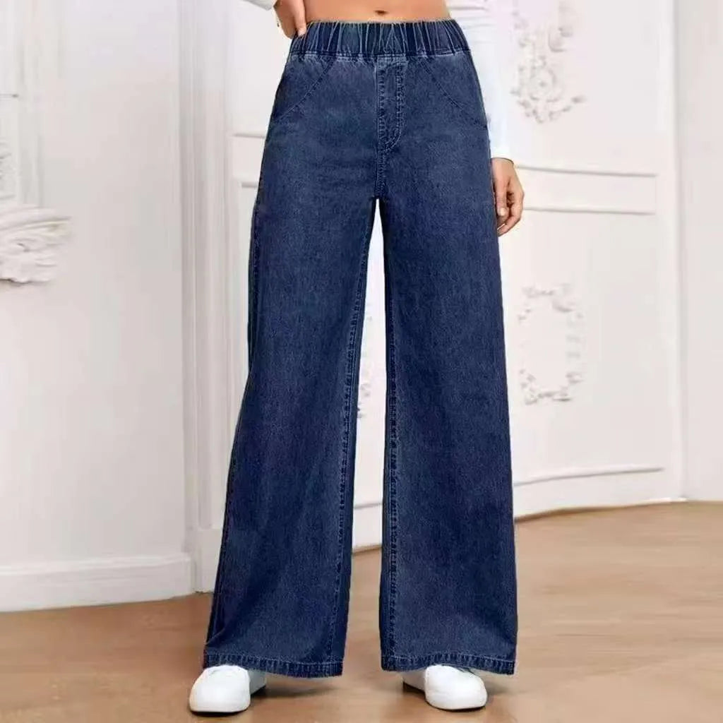 Light blue washed wide-leg straight-leg women's jeans on a hanger, showing mid-waist and zip fly detail.