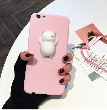A soft pink silicone iPhone case featuring a raised 3D cartoon cat design on the back.