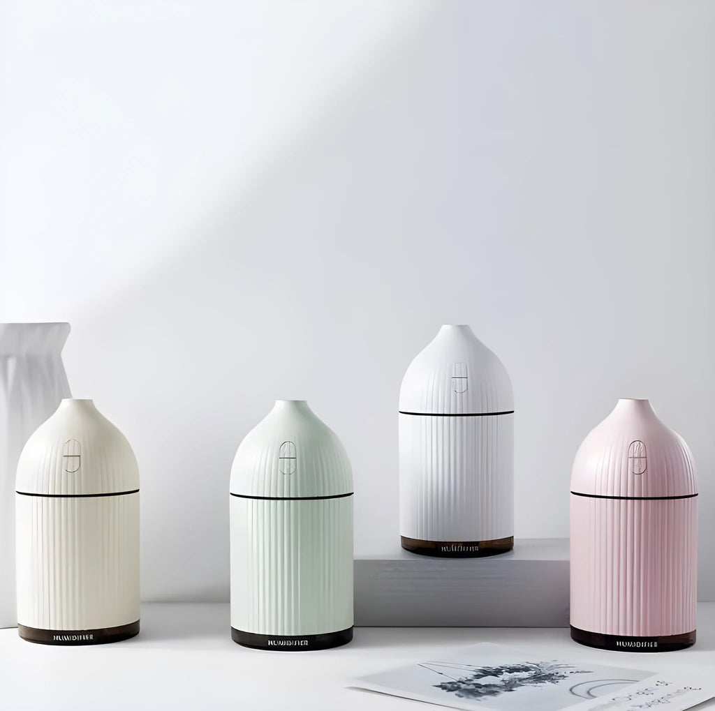 White ultrasonic aromatherapy diffuser and humidifier with 300ml capacity, USB port, and LED light on a wooden surface.