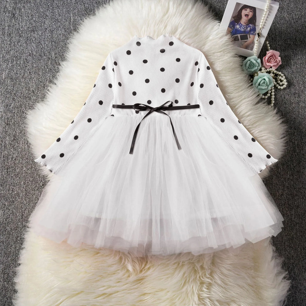 Baby girl in a long sleeve black tutu lace dress for a christening or birthday party.