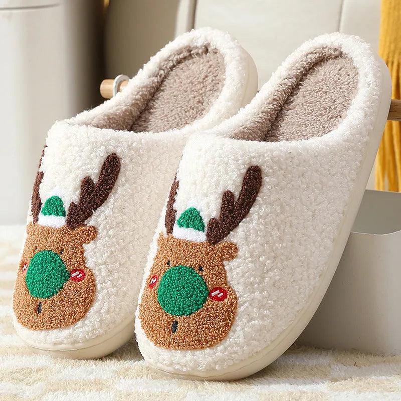 Pair of red Christmas elk plush home slippers on floor, soft anti-slip shoe design
