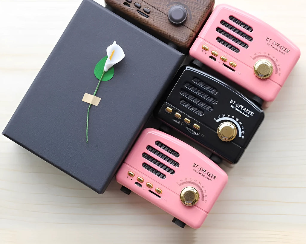 Vintage wood grain Bluetooth speaker in black, pink, and wood grain colours showing compact 93mm design