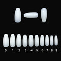 500 clear acrylic false nails in various sizes spread out on a table